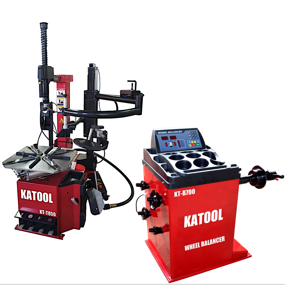 Tire changer and wheel balancer combo machines, red and black units with head arms