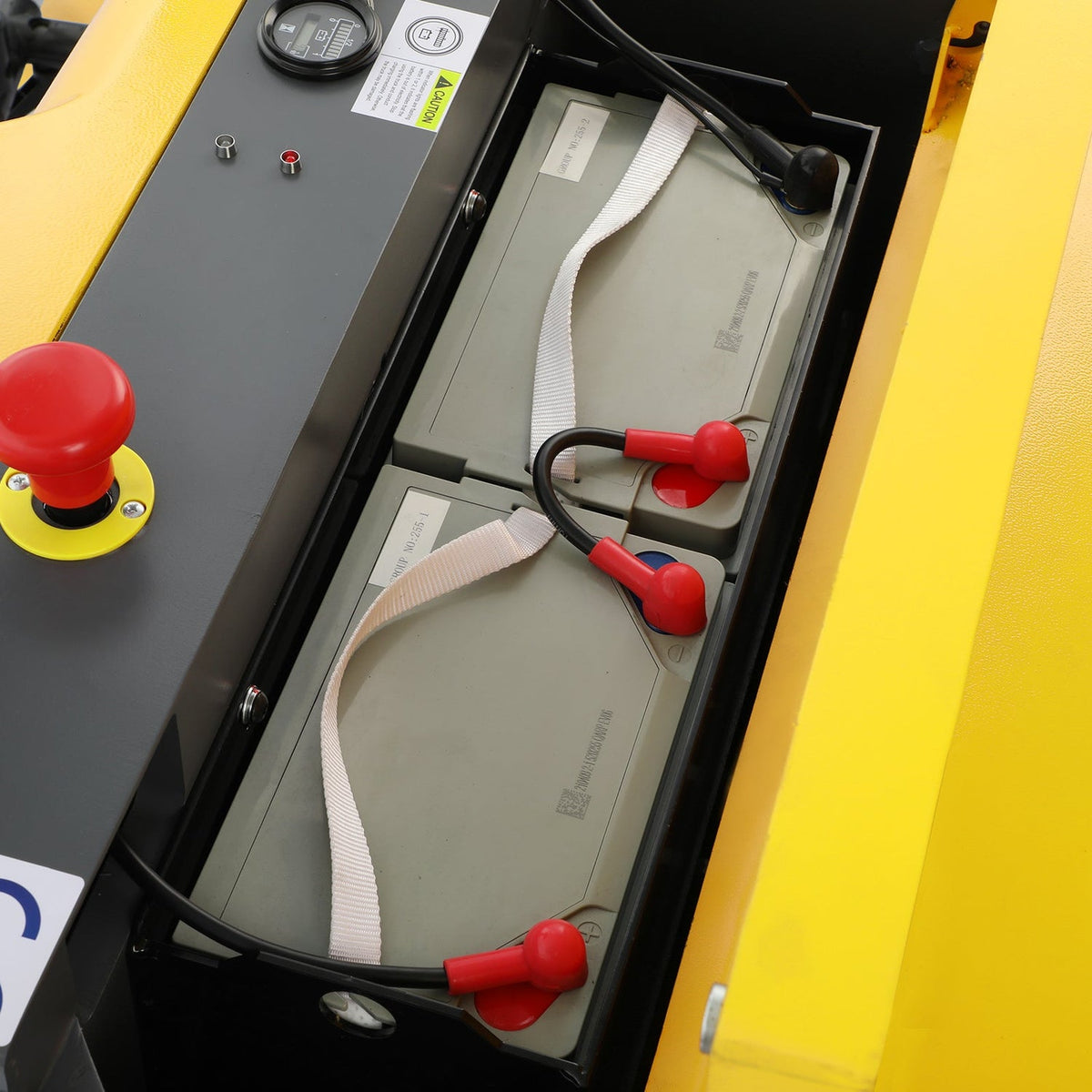 Electric pallet stacker battery compartment with cables and red battery terminals