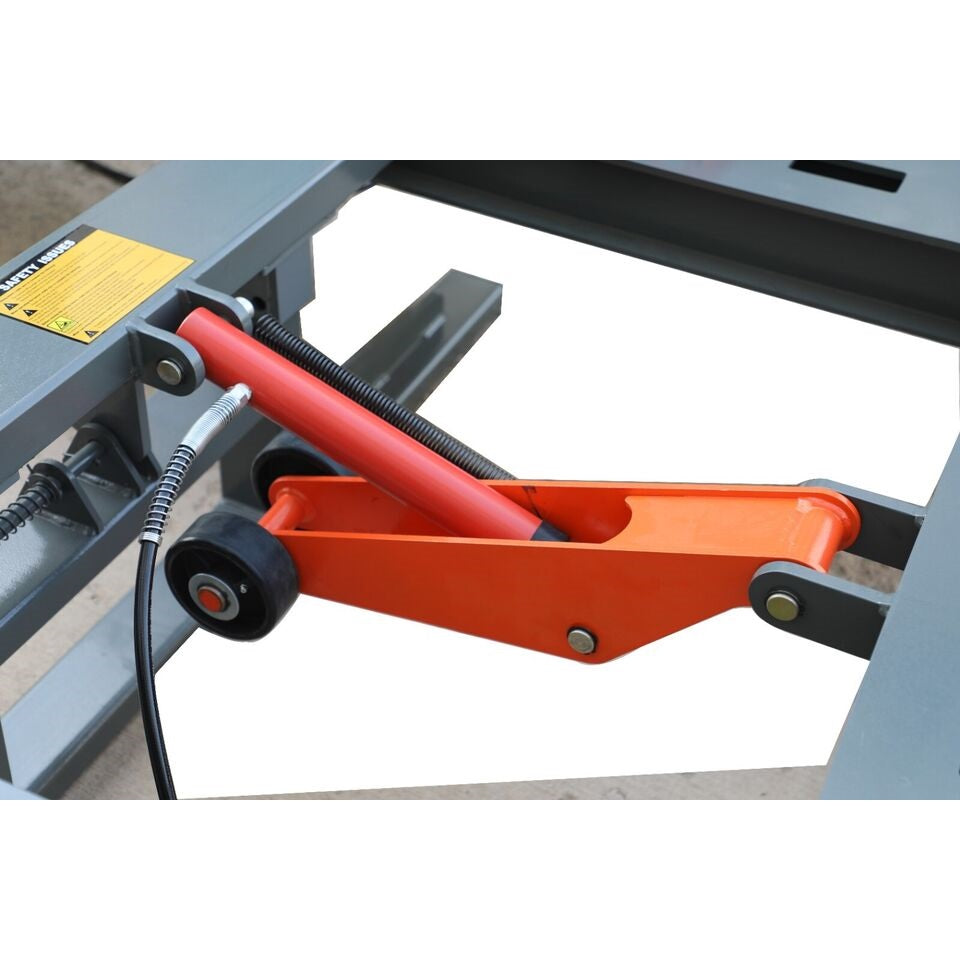 Auto body frame machine pulling head with red bar, orange arm, and cables