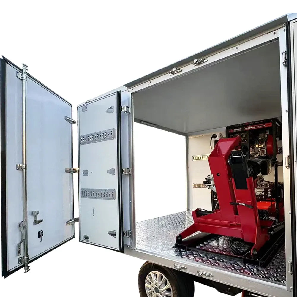 Red tire changer inside open trailer compartment with silver side doors