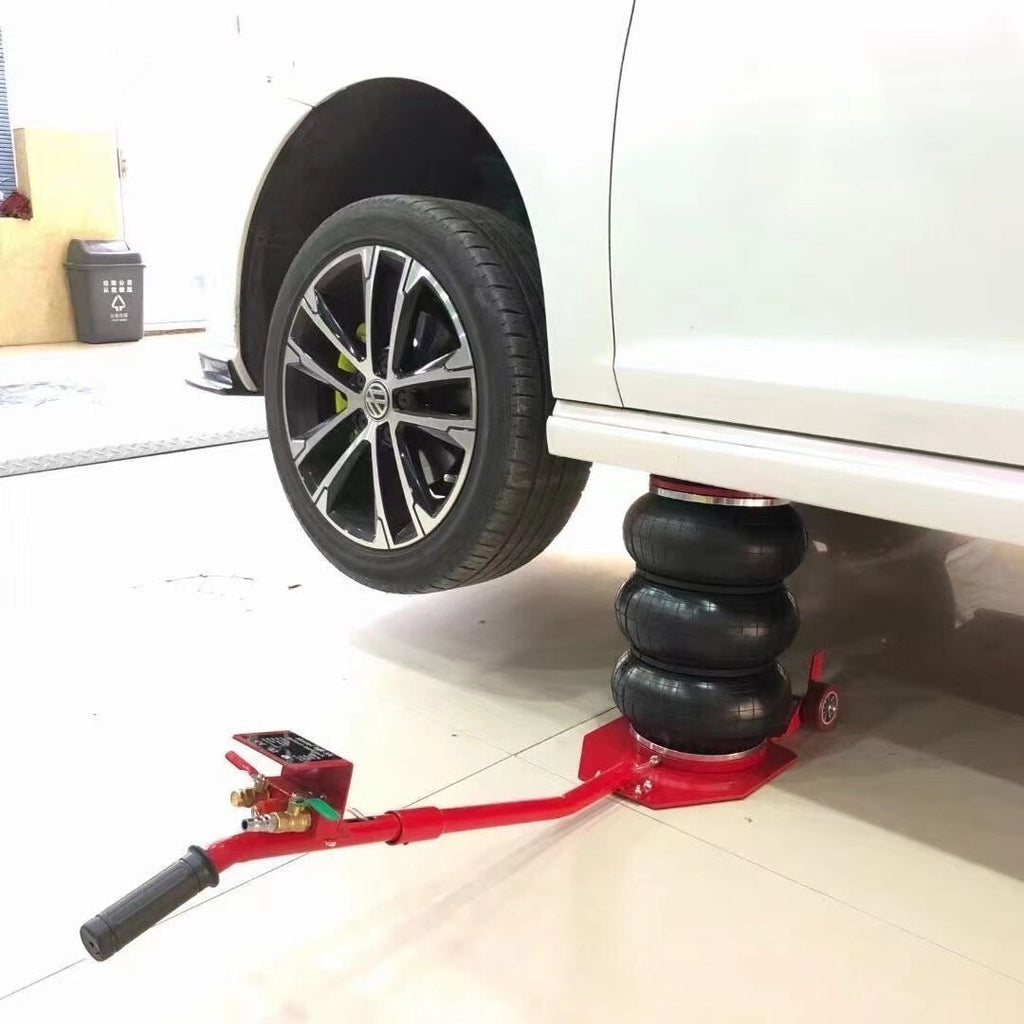 Pneumatic air jack under car with black triple pads and red base