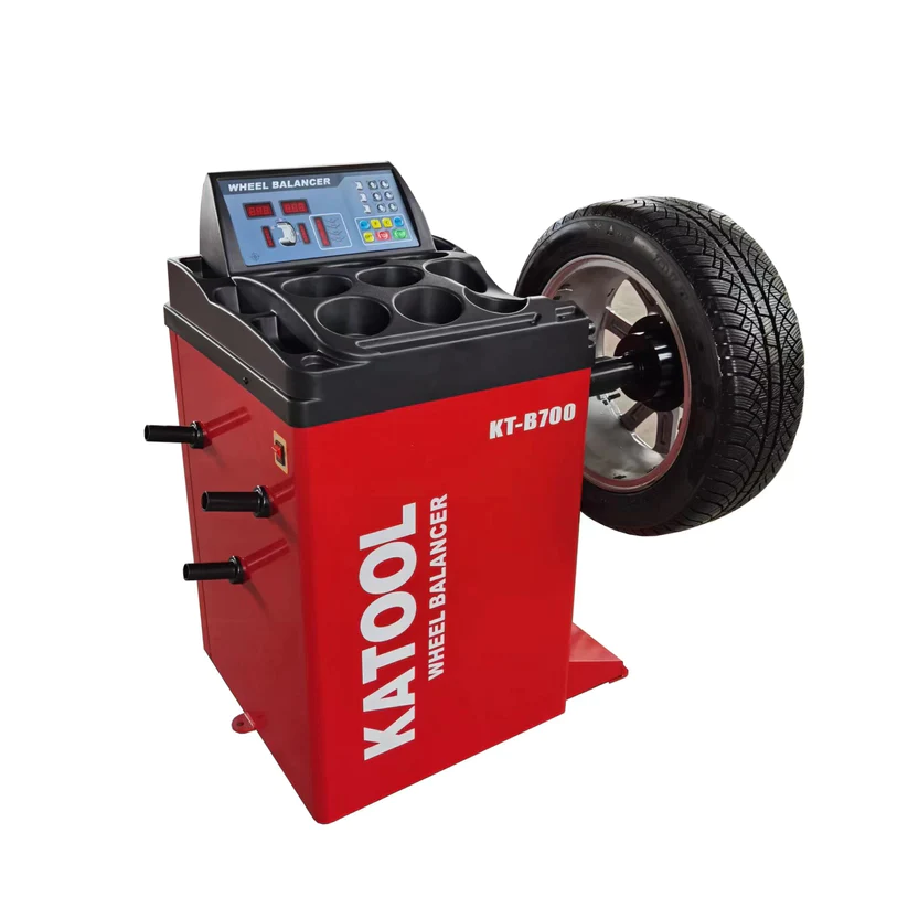 Wheel balancer machine with control panel and tire clamping cone, red and black