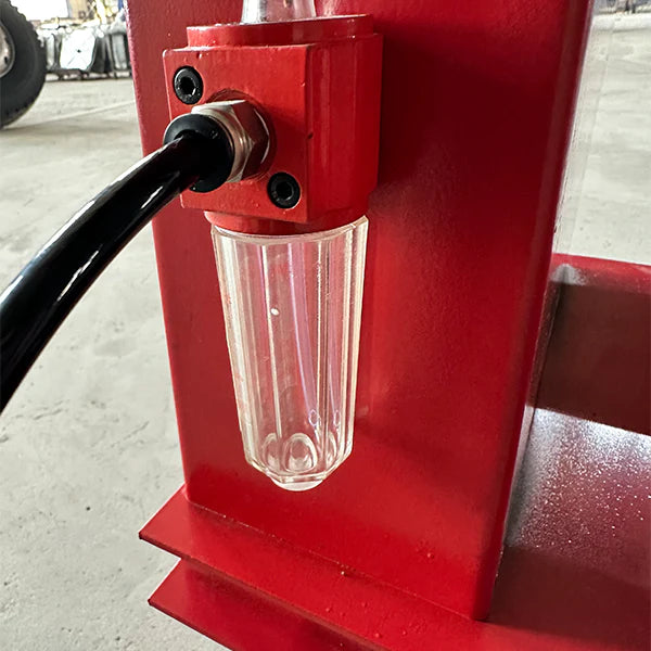 Wheel balancer fluid reservoir with transparent cup and hose connection fitting