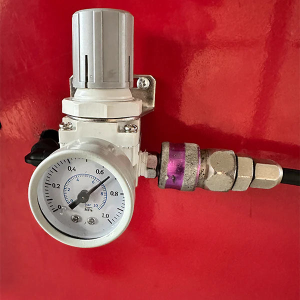 Wheel balancer pressure gauge with dial, regulator valve, and connected tubing