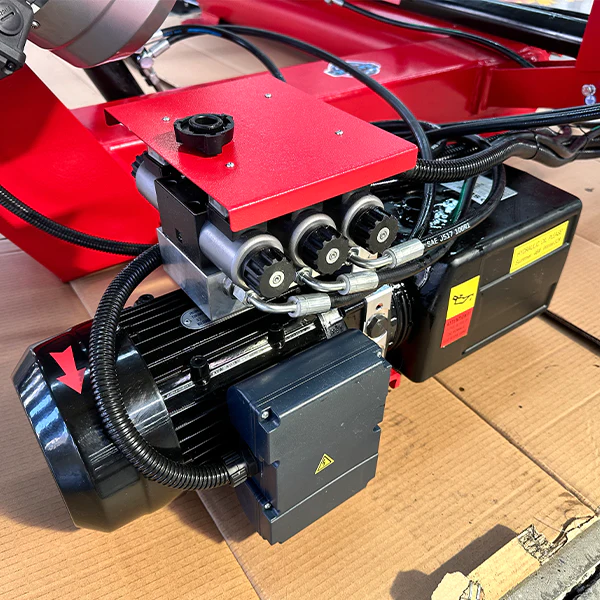 Electro-hydraulic power unit on a red tire changer base with control hoses