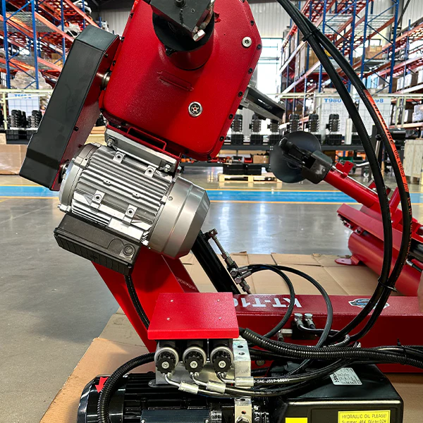 Red tire changer with large hydraulic motor and hose connections