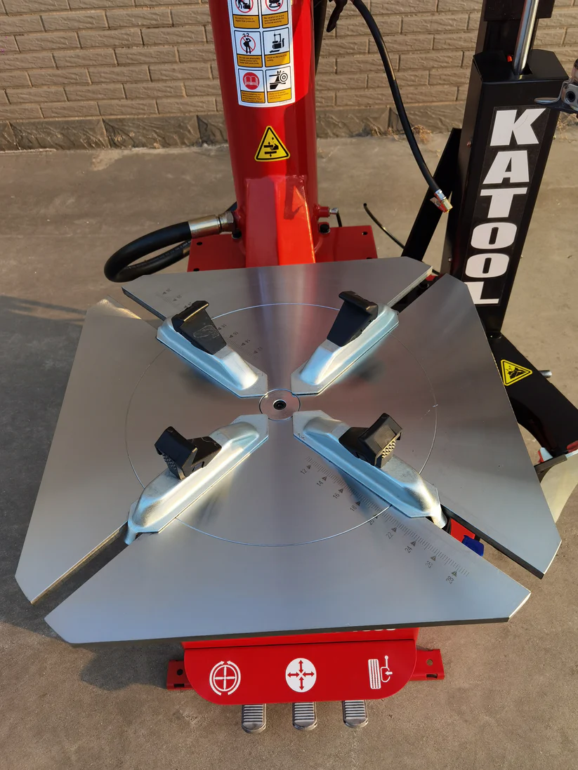 Tire changer turntable with four silver bead tools and red indicator base
