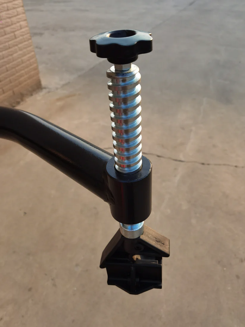 Tire changer bead tool with coiled spring, black handle, and foot support