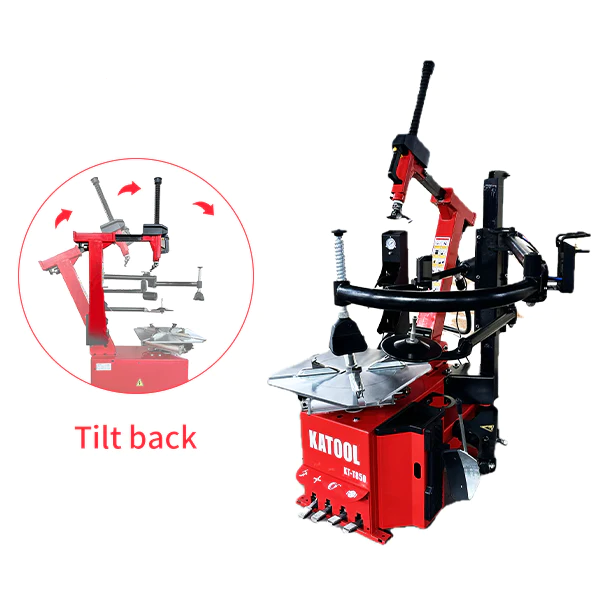Tilt-back tire changer with wheel clamp and mounting arm over a metal turntable