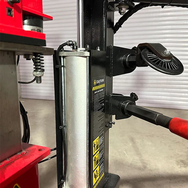 Vertical press cylinder with control panel and black handle arm, close-up view.