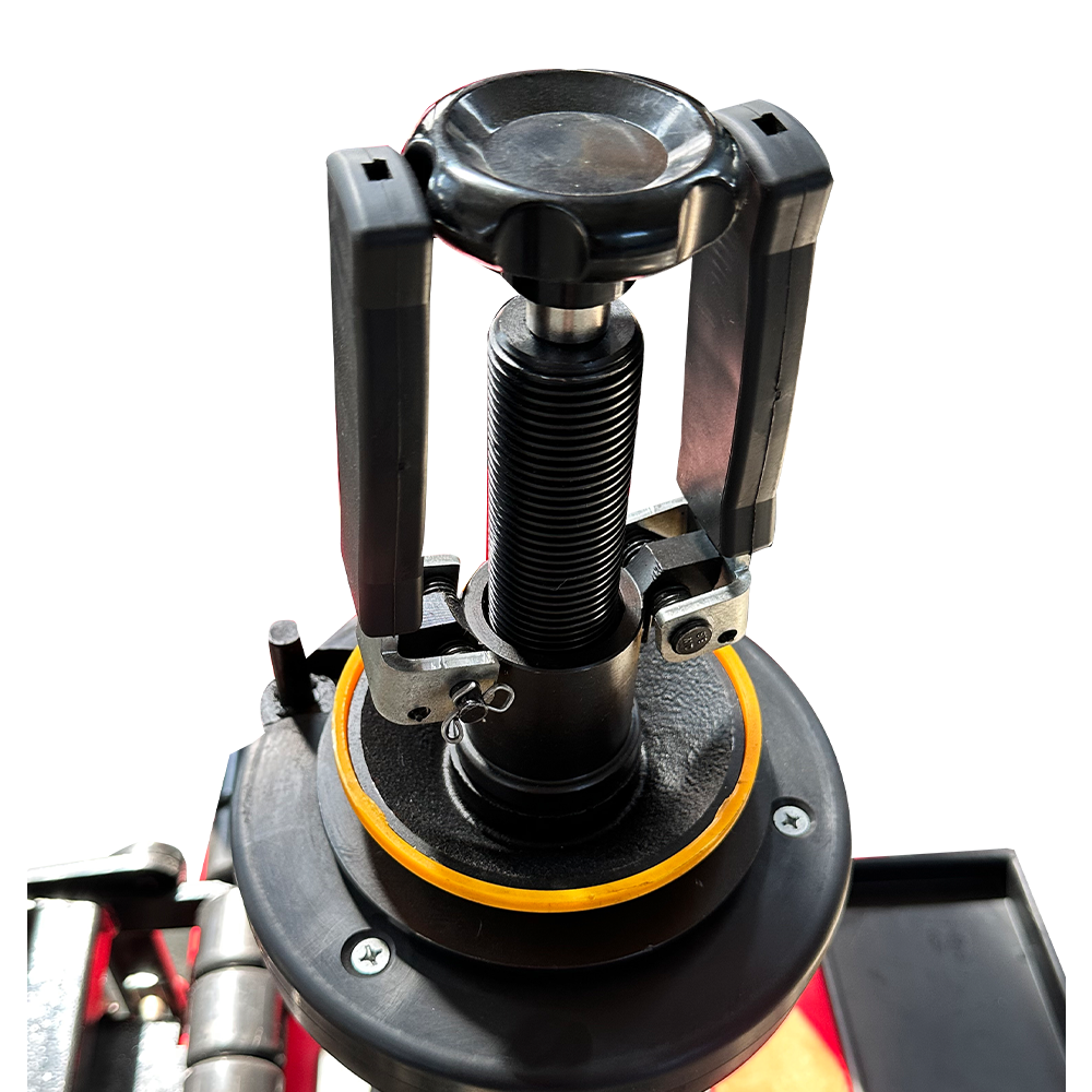 Automatic tire changer bead tool assembly with black housing and spring, close-up
