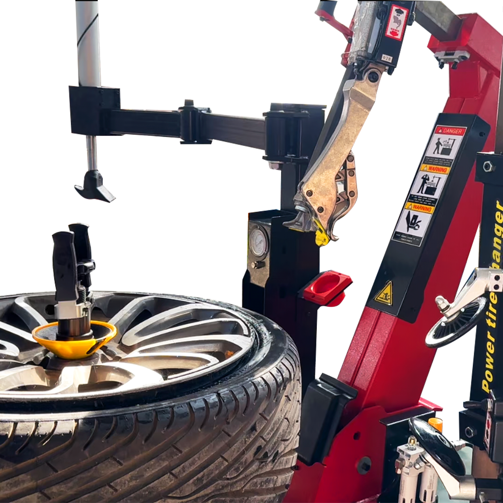 Tire changer head above car wheel with yellow contact tool and metal clamps