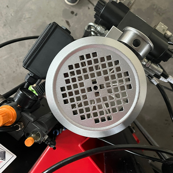 Tire changer turntable with circular perforated plate and metal mounting clamps