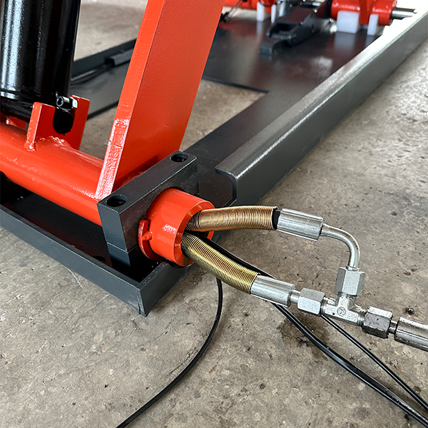 Orange hydraulic actuator and threaded screw on an electric scissor lift base