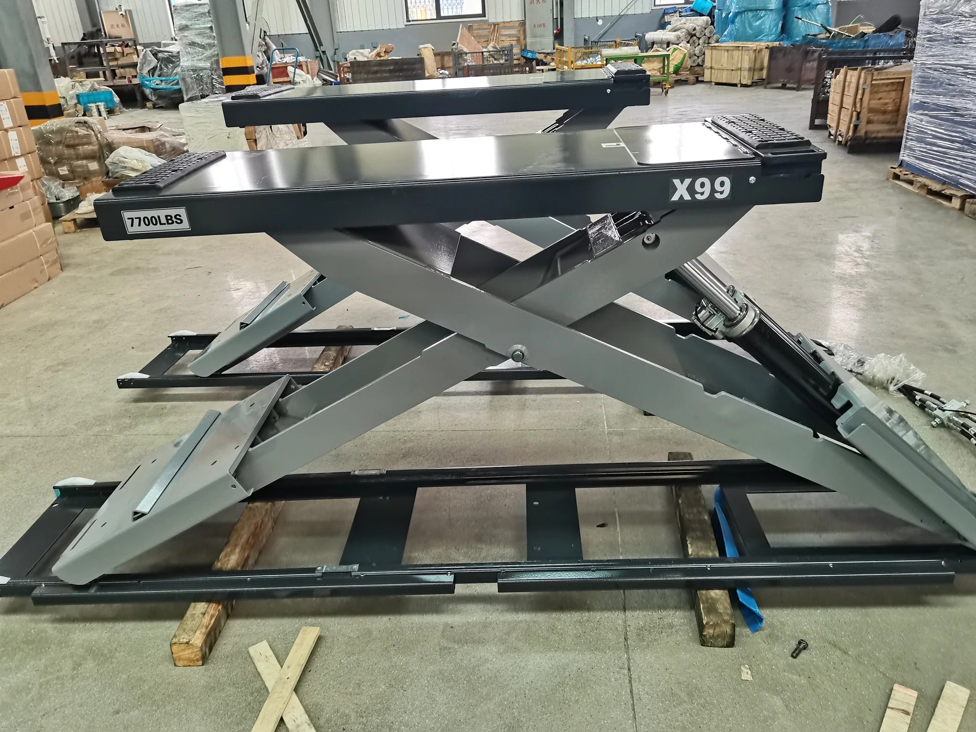 Full-rise scissor lift with gray scissor arms, X99 beam, and red load pads