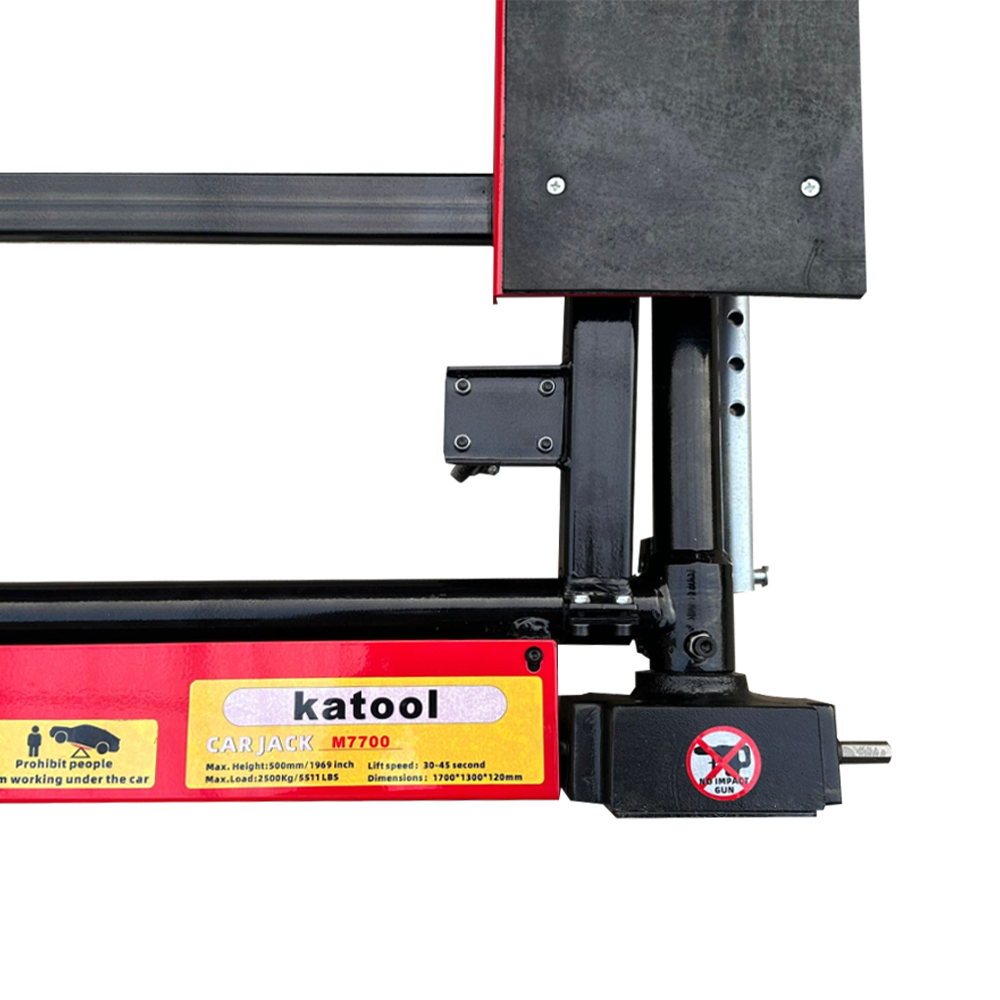 Car jack base close-up with control housing, warning label, and vertical lift post