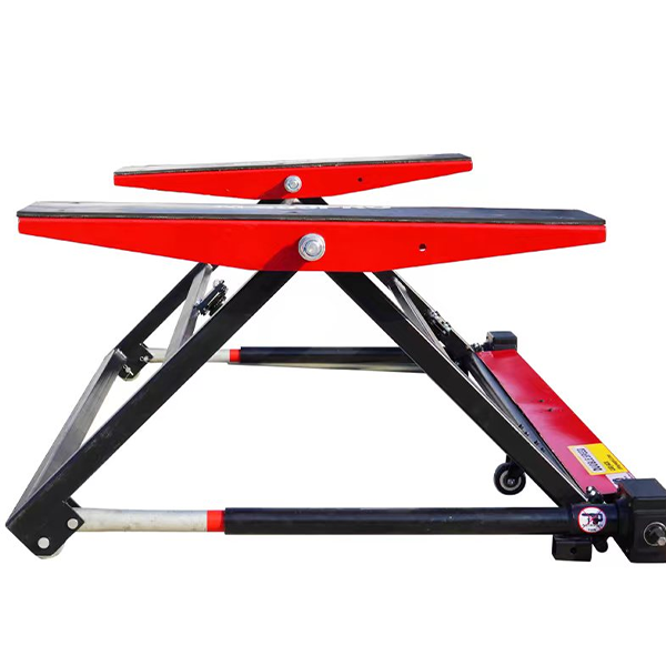 Scissor-style floor car jack with red and black lift platform and caster feet