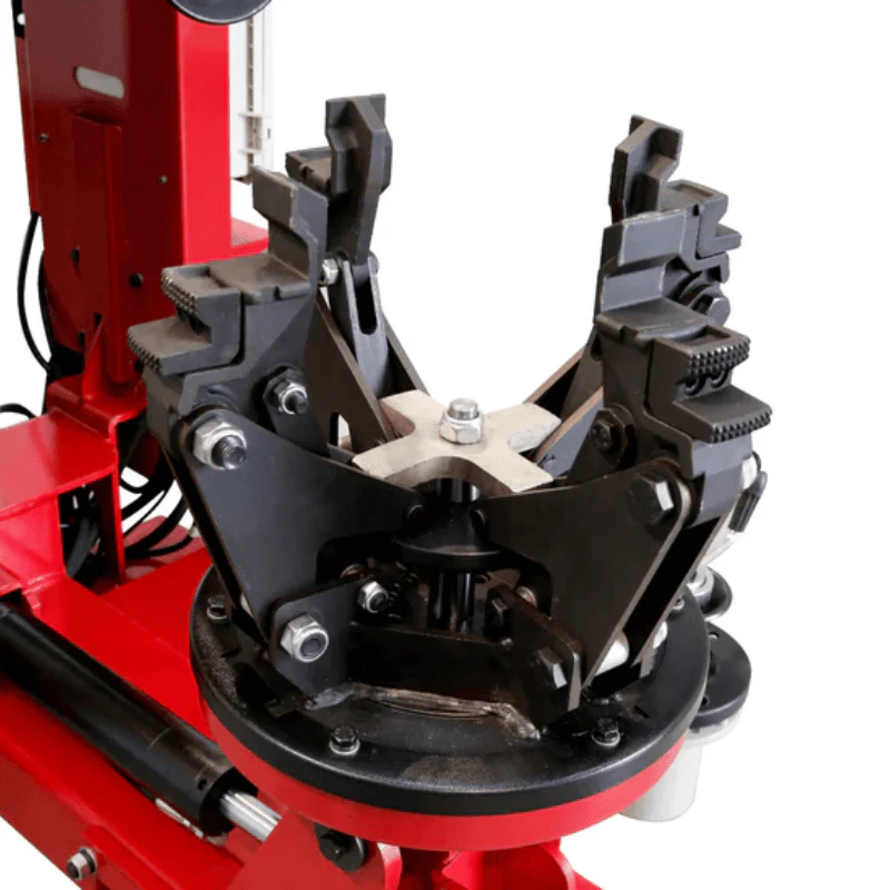Wheel clamping device on black turntable with gray jaws and mounting hardware