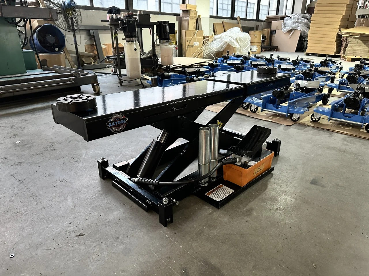 Katool rolling jack on shop floor, black frame with scissor lift and pump