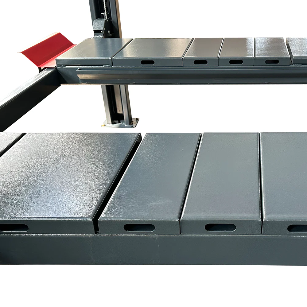 Black steel runways with slots and red release plate on 4-post lift