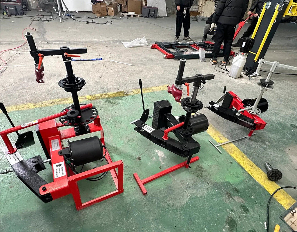 Mini tire changers in workshop floor setting with red frames and black bases