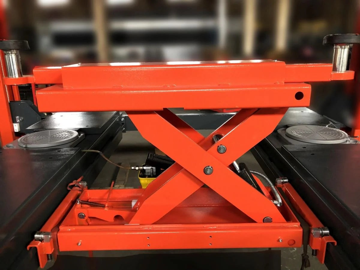 Orange scissor lift rolling jack showing platform pads and X-frame support structure