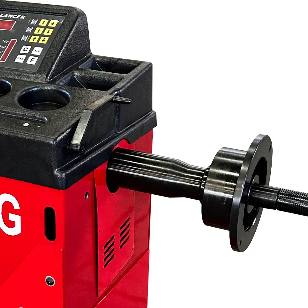 Wheel balancer spindle shaft with black hub and red machine body from control side