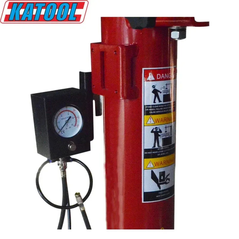 Red tire changer column with pressure gauge and safety warning labels