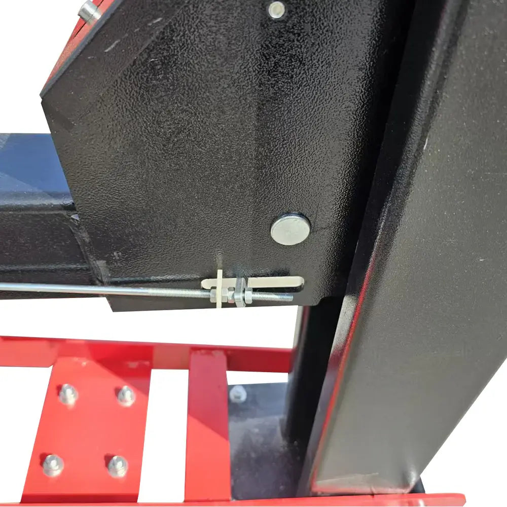 Lift arm end and steel hardware with textured black plate and red support beam.