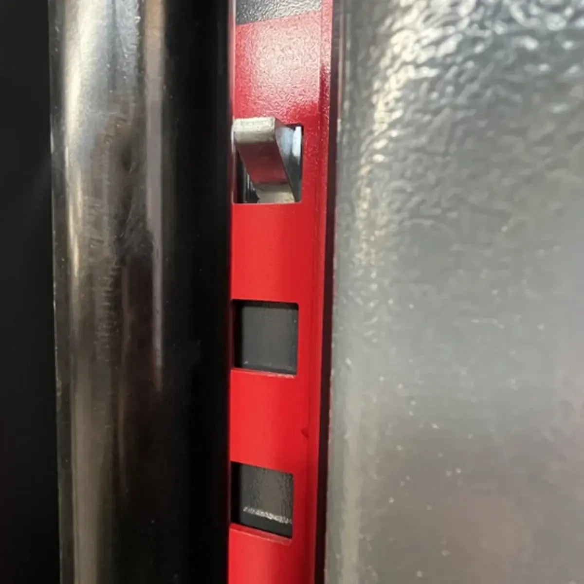 Two-post car lift locking plate area on the dark column with red frame
