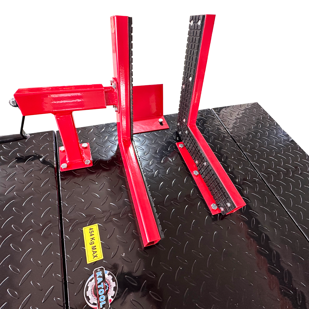 Hydraulic motorcycle lift base with diamond-plate deck, red legs, and warning label