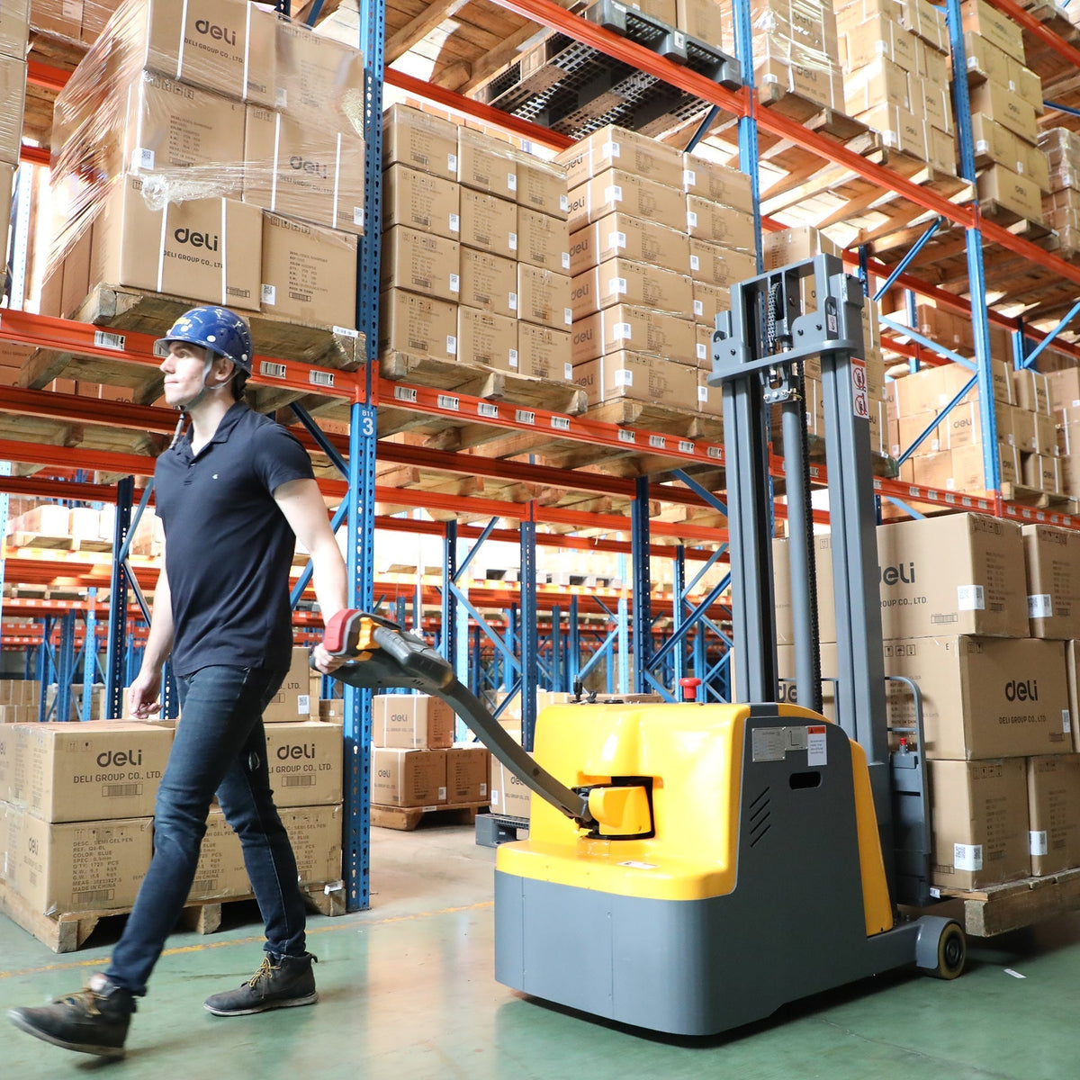 Yellow counterbalanced pallet stacker with forks raised in warehouse aisle